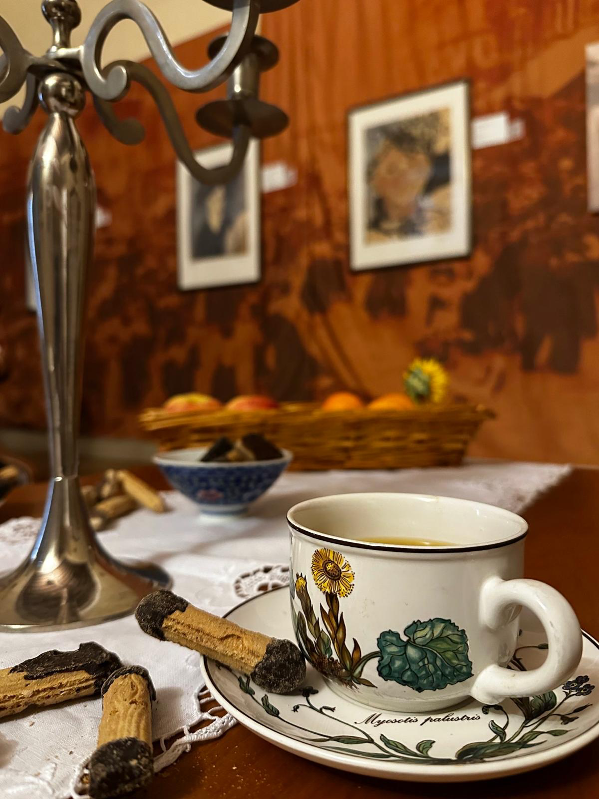 Un tavolo apparecchiato nell’ambientazione della mostra, davanti alle immagini delle opere